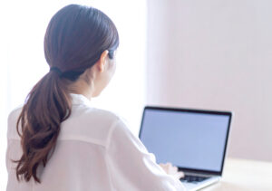 【無料素材】ノートパソコンを操作する女性の後ろ姿